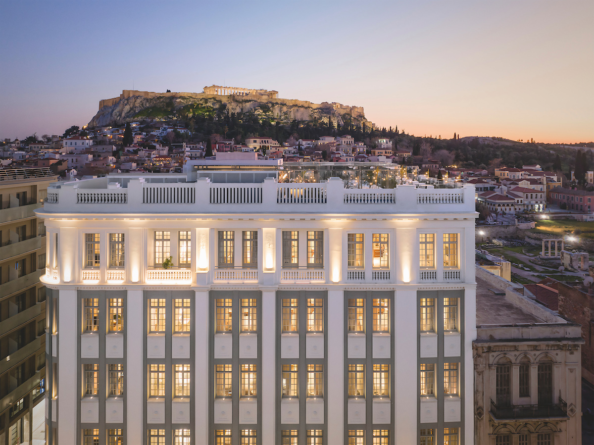 A lit-up The DOLLI at Acropolis with Athens as its backdrop