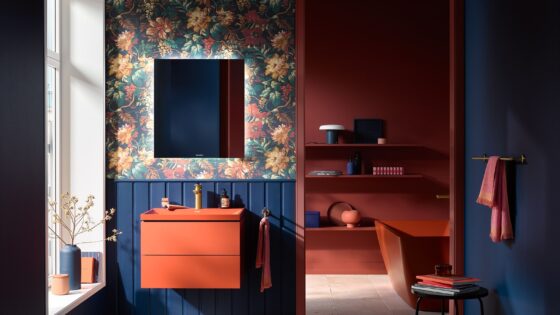 dark orange basin and vanity by Duravit against blue wood panelling and floral wallpaper