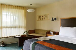 rustic guestroom with patterned throw and art work on the wall