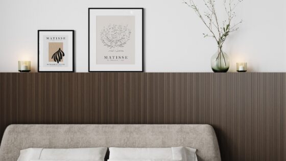 oak veneer headboard with framed pictures and vase above bed