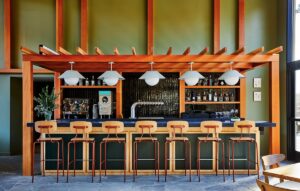 wooden bar with bar stools in front of tiled wall in Trailborn Rocky Mountains Casa Collina