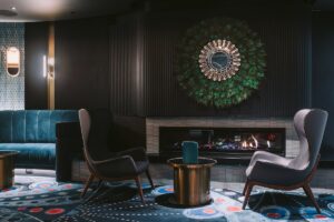 casino and hotel corridor with blue patterned carpet and lighting focussed on black and white portraits on the blue wall