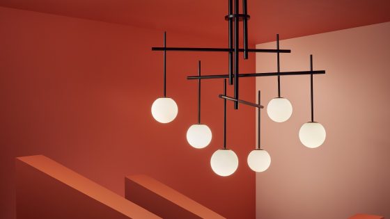 contemporary lighting design with black structure and round glass shades by Chelsom against a terracotta background