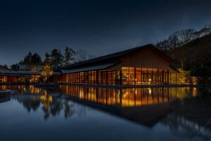 exterior view of evening lights lighting up the interior of Roku Kyoto