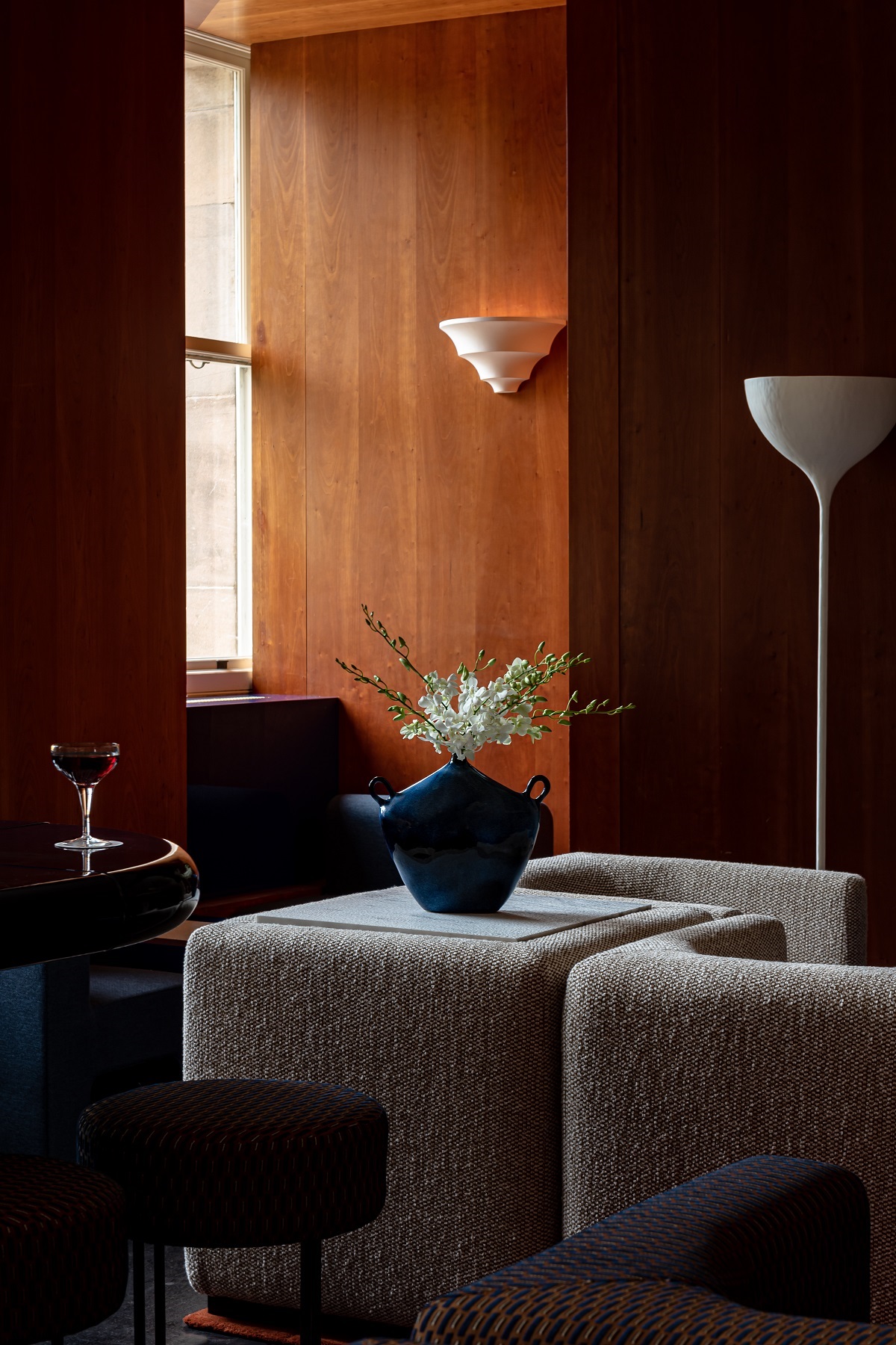 dark wooden panelling and soft cream furniture in a window corner