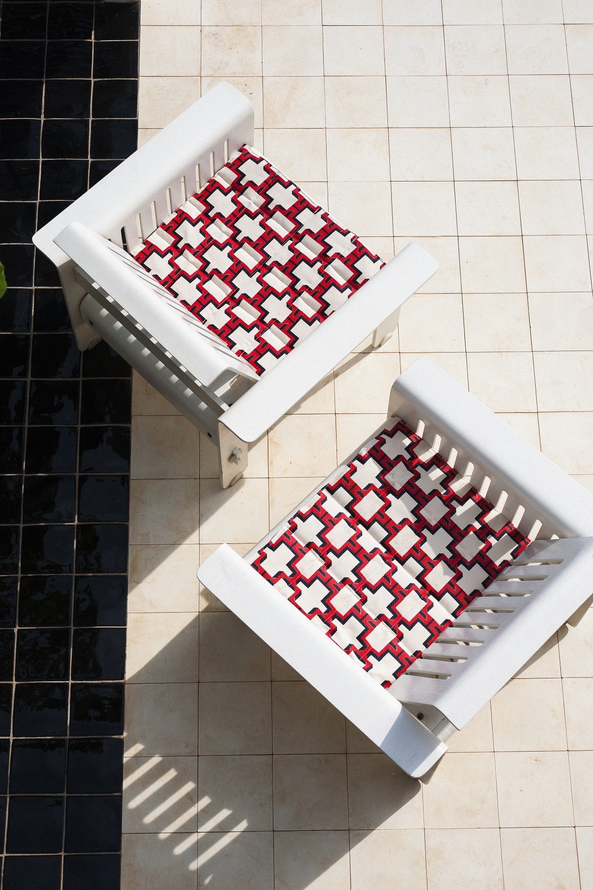 deckchairs on a black and white tiled surface with seats in fabric from Dedar Campus