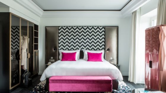 Hotel suite bedroom with pink accents on bed and mosaic floor, in Fauchon L'Hotel Paris