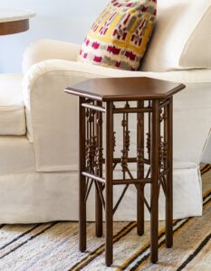 side table with decorative turned legs next to a cream couch with a patterned cushion