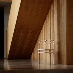 wooden bentwood chair against wooden panlled wall under wooden staircase