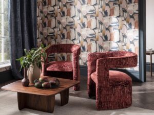 organic shaped chairs in a spice coloured fabric from Clarke & Clarke set against bold abstract wallpaper