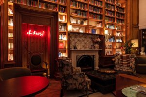 neon oh deer writing in the fireplace of the funny library in virgin Edinburgh interior design by Ica