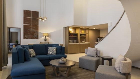 Image of large suite with staircase and blue furniture