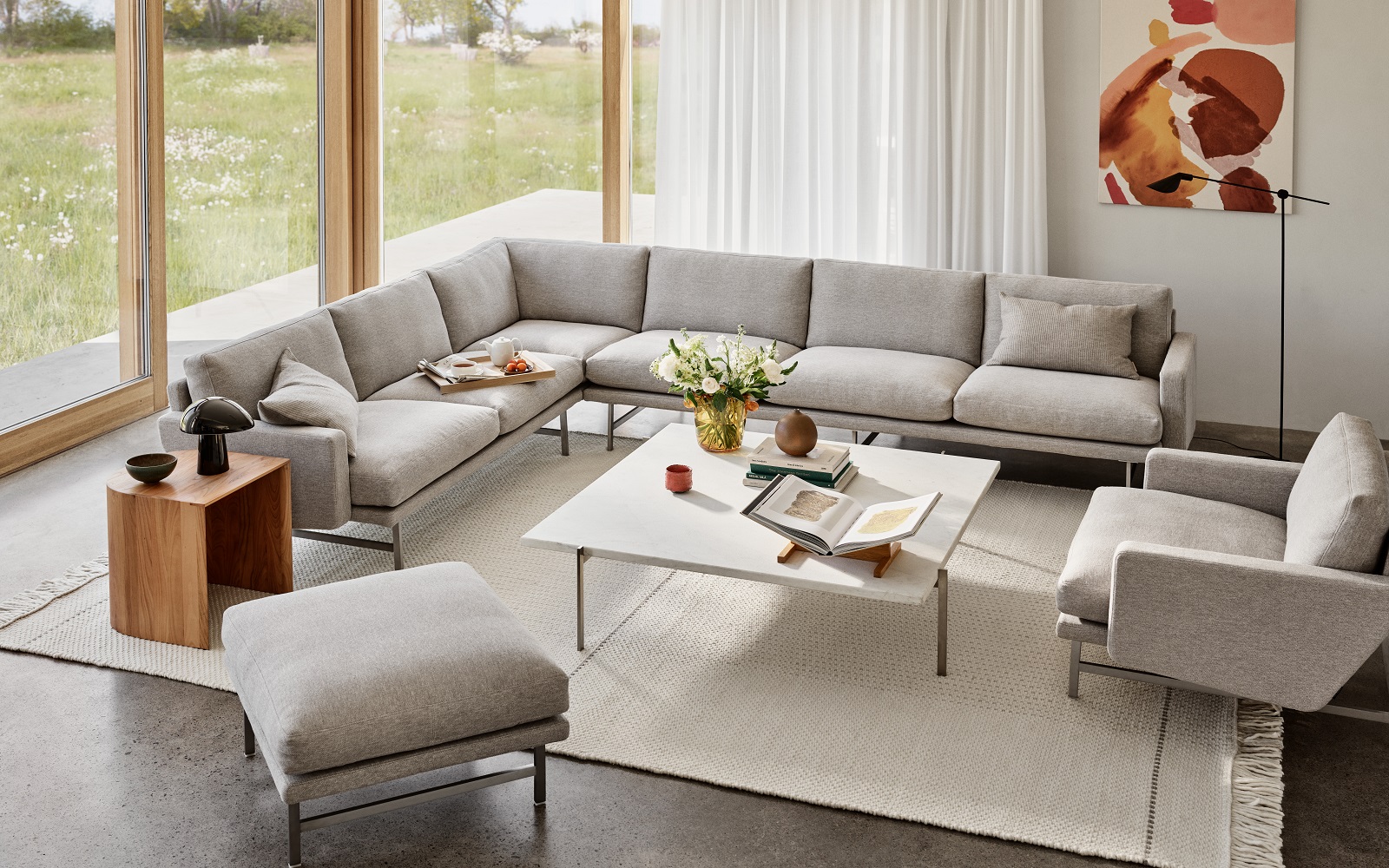 cream L shaped Lissoni couch from Fritz Hansen in front of floor to ceiling window