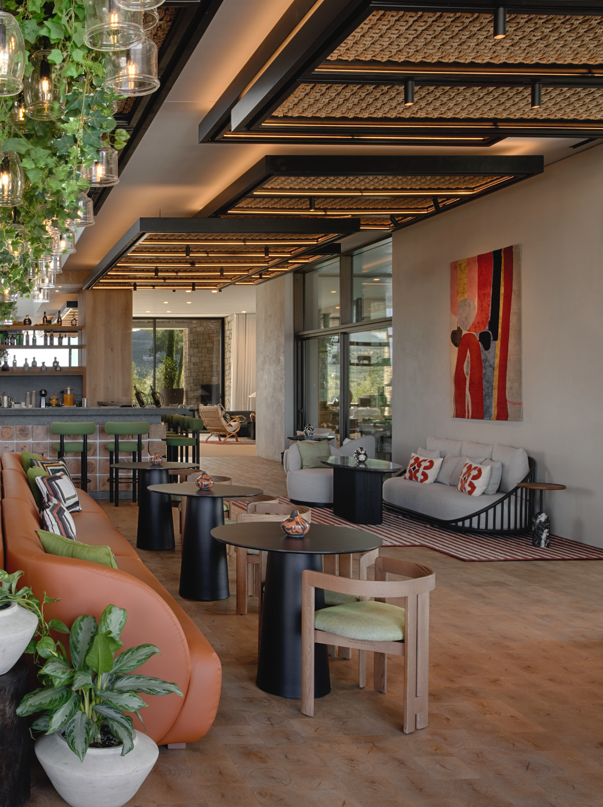 W Greece interiors - light, minimalist space in the lobby with plants on ceiling and rounded sofas