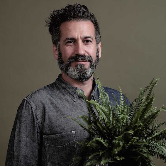 An image of Oliver Heath holding a a plant