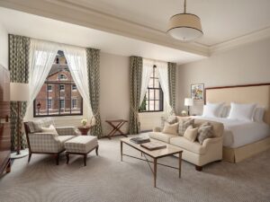 cream, white and wood guestroom with bedside light, ceiling light and standing lamp all designed by Northern Lights for Raffles London