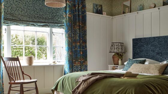 bed and rocking chair in front of window with velvet curtains and blinds and green velvet bed cover from Morris & co collection