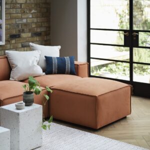 brick wall, wood floor and saffron coloured furniture in earthy tones in a room