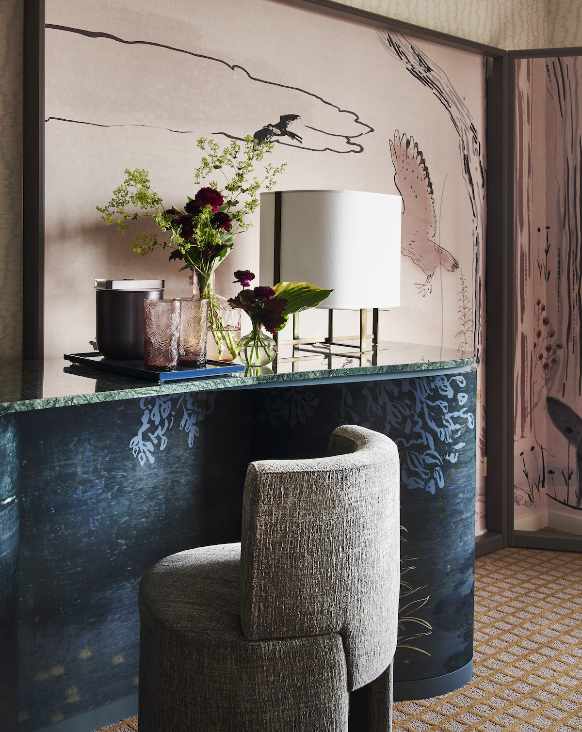 Close-up of vanity area / desk in suite with navy blue, textured desk and soft seating