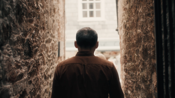 Jeremy Grove walking between two buildings